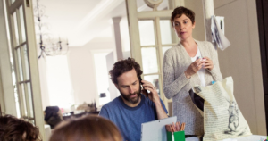 family at table, parent with laptop