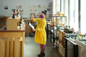 Retail employee with mask reviewing inventory for a curbside pickup order in Excel on OneDrive.