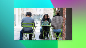 Women sitting at table on computer with green background