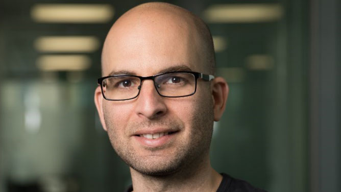 Ariel Gomez Diaz wearing glasses and smiling at the camera