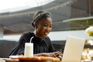 A young woman works remotely on her laptop.