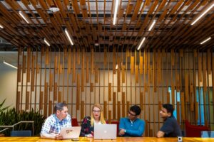 A group of tech workers hold meeting in common space of U.S. office.