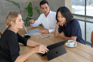 Small group of professionals working on laptop in office.