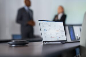 Camera focused on laptop screen showing security dashboard while security decision makers present to the board of executives on security topics.