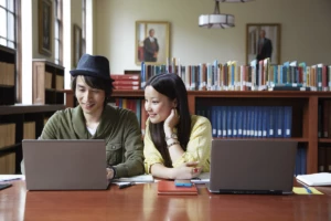 Colleagues working in a library on laptops