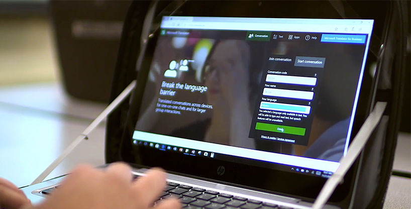 一名学生在笔记本电脑上使用浏览器中的Translator多设备对话功能。