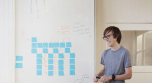 a person standing in front of a whiteboard