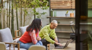 a person sitting at a table using a laptop