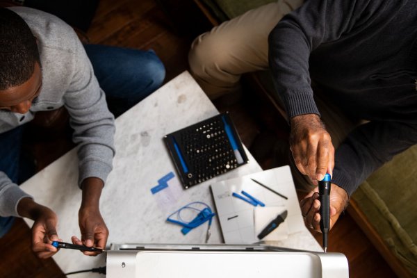 Aerial shot of two people fixing a PC with an iFixit toolkit.