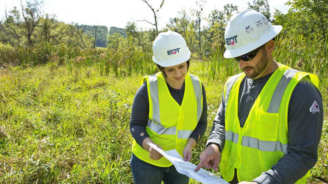 EQT employees in the field looking at a piece of paper