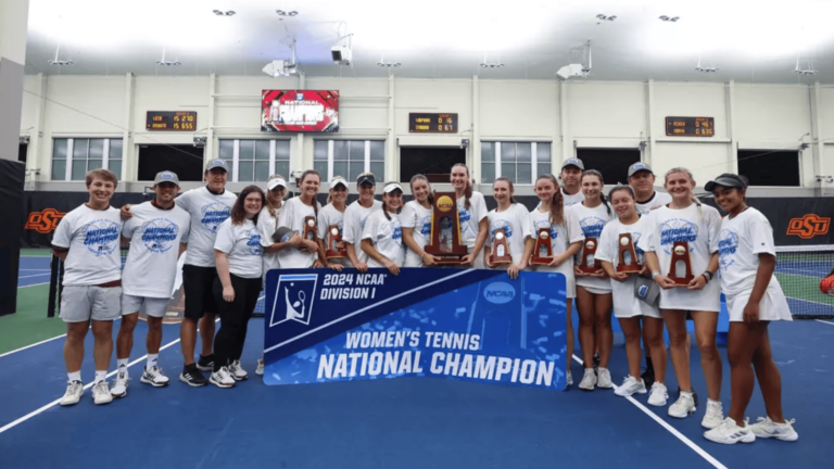 The Texas A&M women's tennis team pose with their trophy and a sign that reads "Women's tennis national champion"