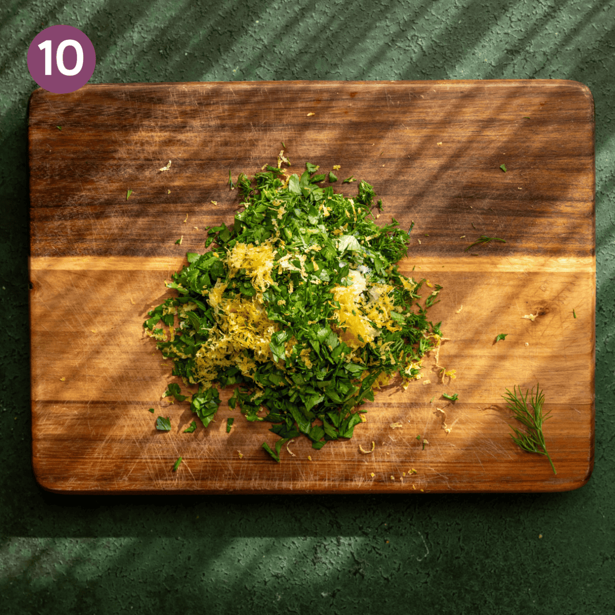 Chopped herby oil ingredients on cutting board (minus the oil).