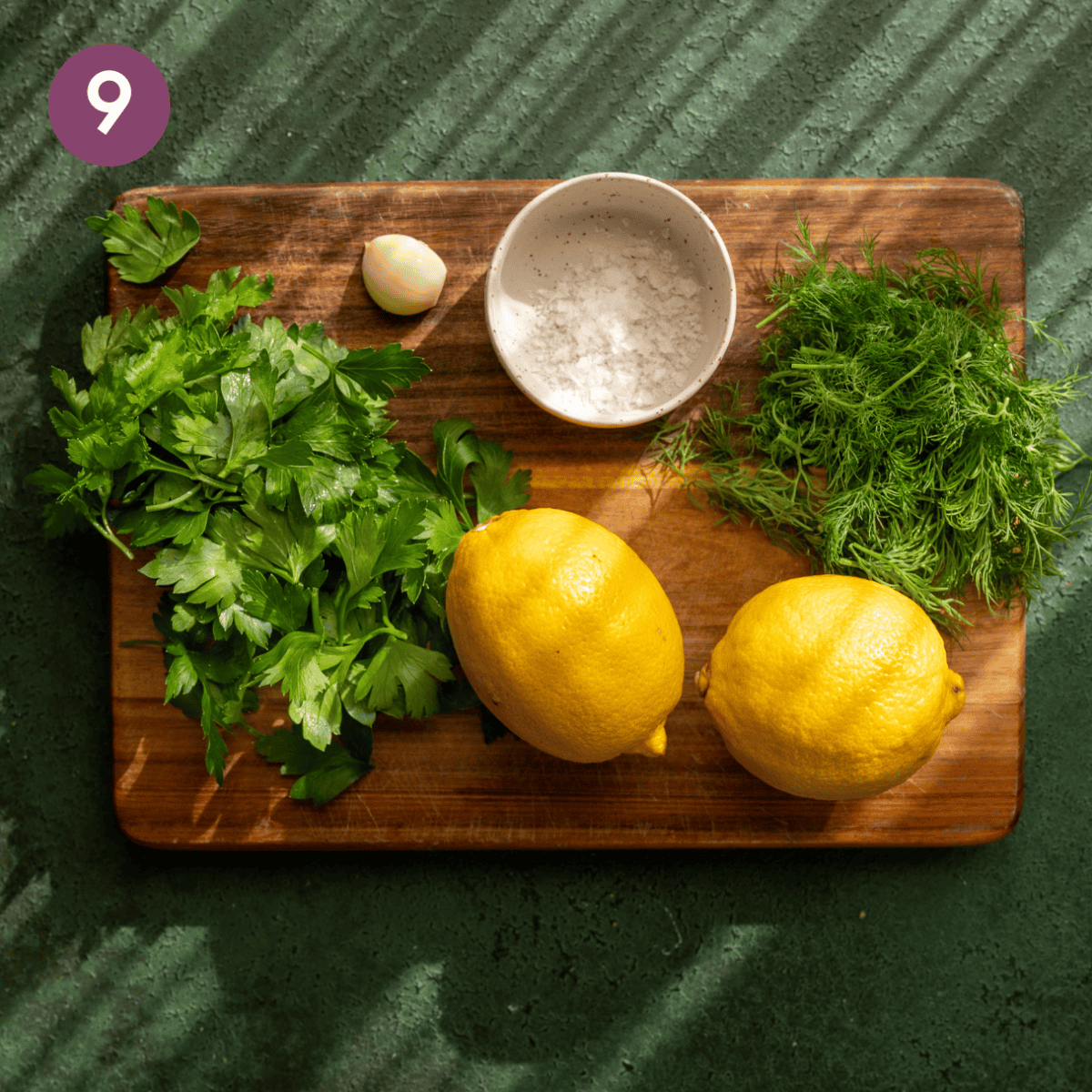 Lemony herb oil raw ingredients on a wooden cutting board.