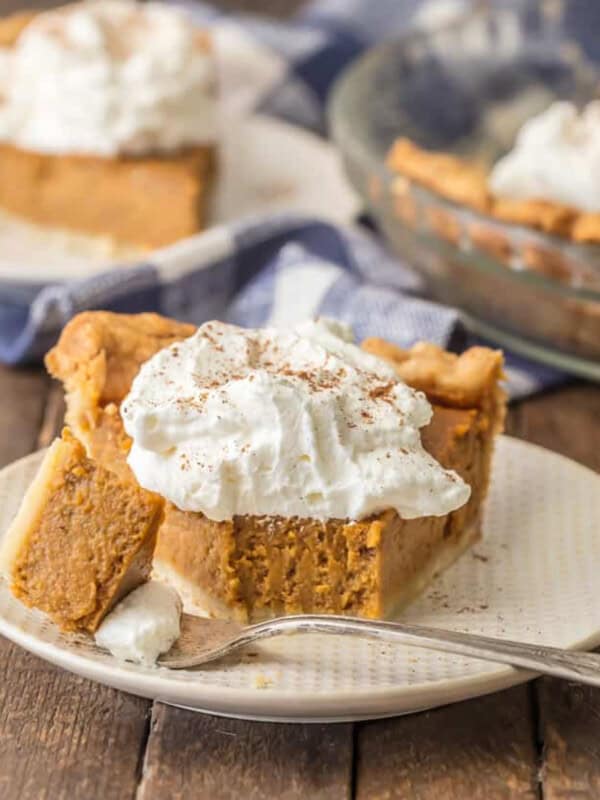 A slice of "pumpkin pie" on a plate with whipped cream.