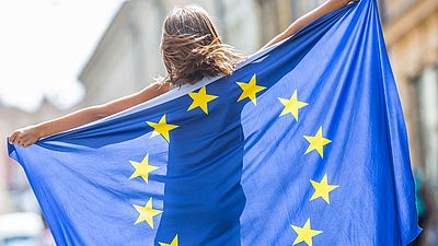 Junge Frau hält eine EU-Flagge