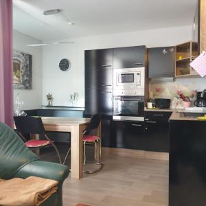 a kitchen with black cabinets and a wooden table at FeWo Regenbogen. Jeden Tag bunt starten! in Altenau