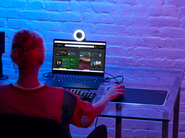 View from behind a woman's head as she accesses the game page on Microsoft Edge on a laptop computer