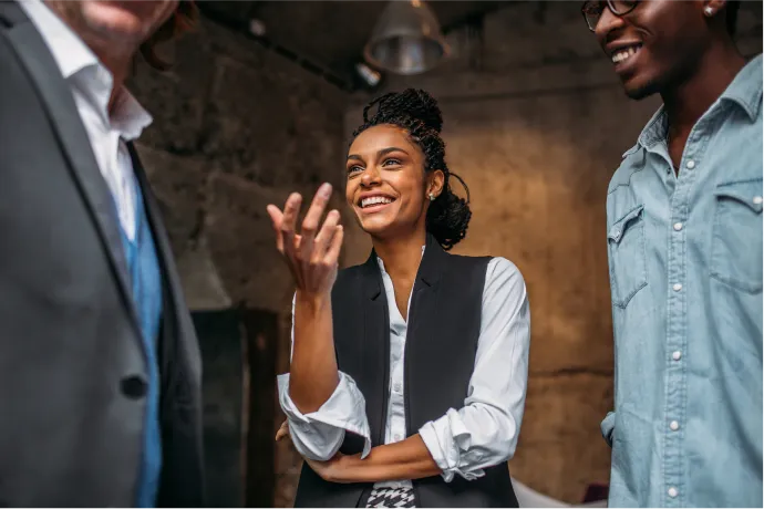 A woman smiling and talking to colleagues