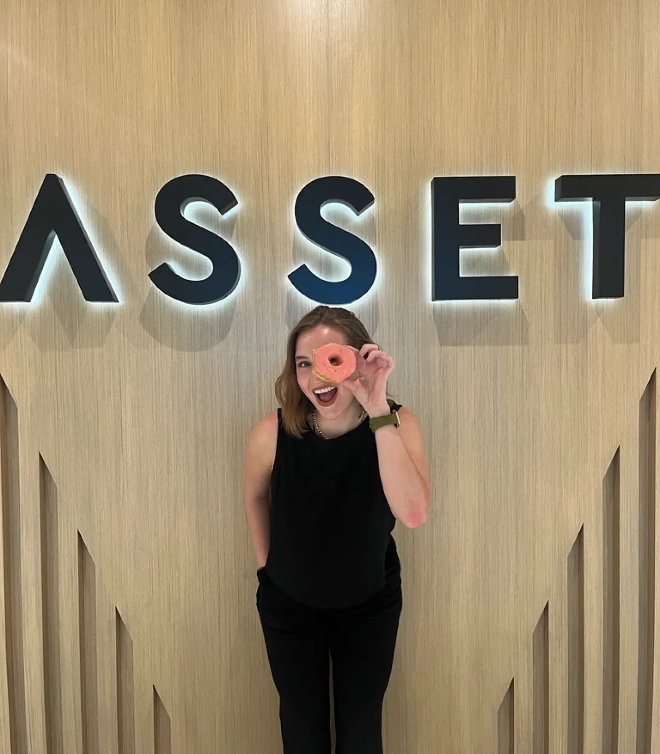 asset employee standing underneath their logo at Asset headquarters