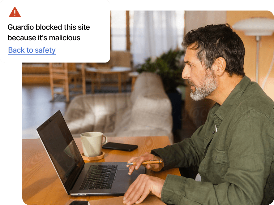 A Guardio user gets a Guardio alert message about malicious site block on his laptop