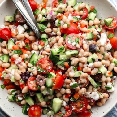 a Mediterranean white bean salad in a large white bowl.