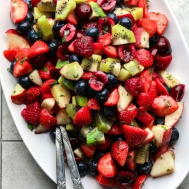 close up on a fruit salad on a white serving plate.