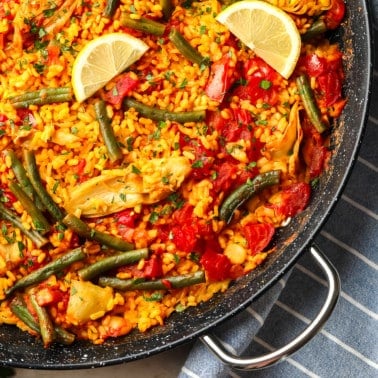 close up on vegan paella in a large black paella pan.