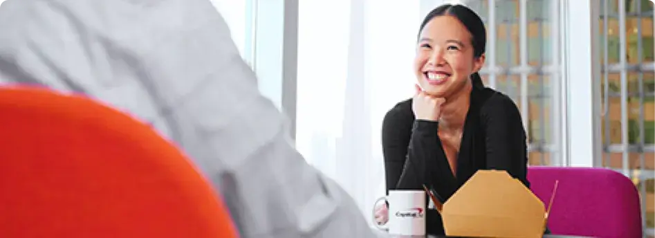 woman smiling while attentively paying attention to a speaker