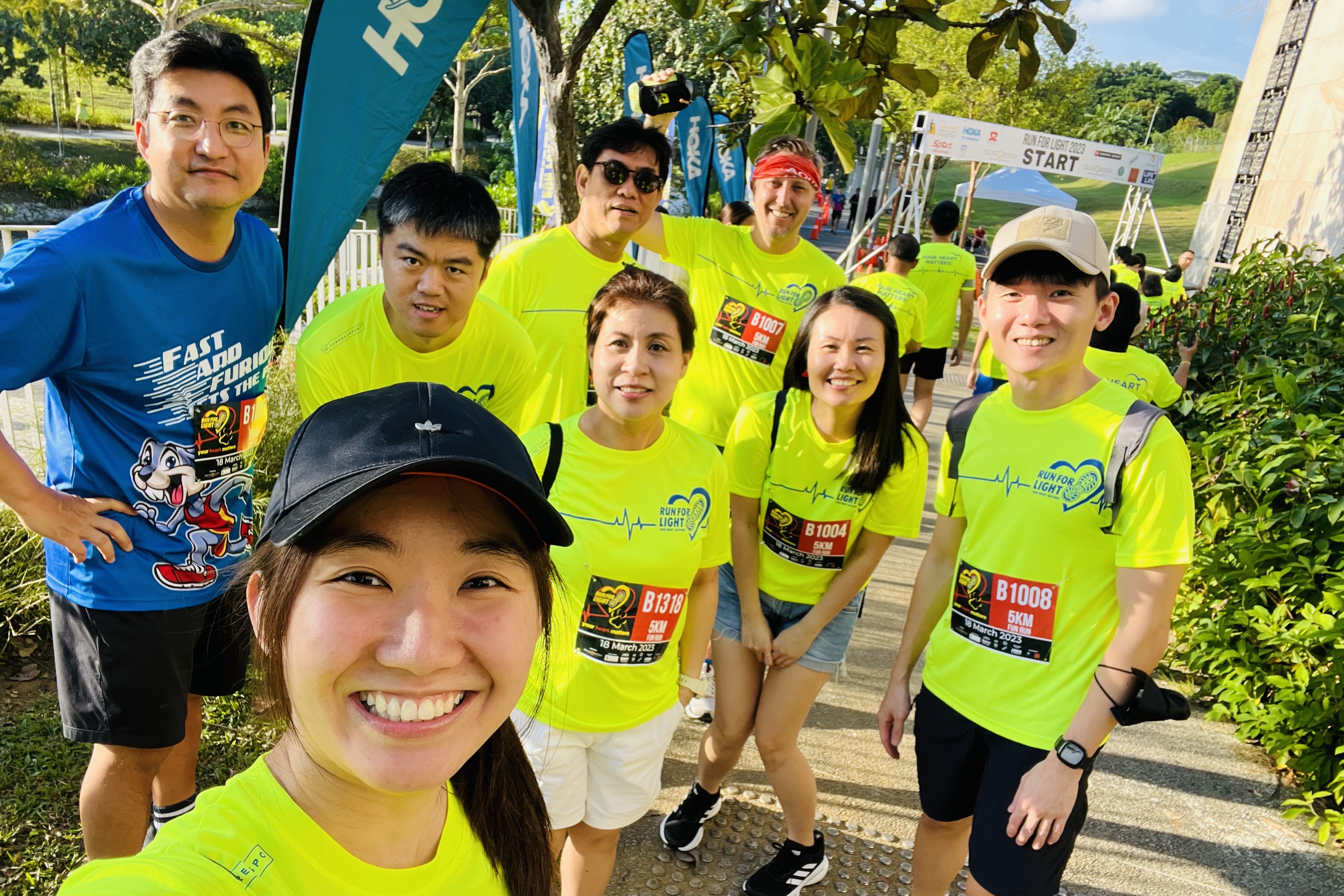 Yan Liang takes a selfie with a group of people at a 5k fun run.