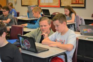 teacher helping student in classroom