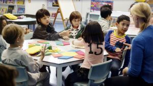 elementary students interacting with teacher in classroom