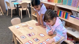 2 girls working together on a project at a classroom table