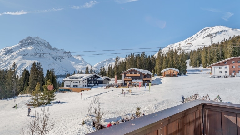 Symbolbild für Skihotel Arlberg: Ausblick vom Balkon der Gold Junior Suite des Luxushotel Sonnenburg auf verschneite Berge und die Skipiste