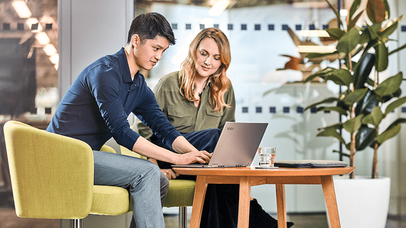 Man and woman viewing something together on a laptop.