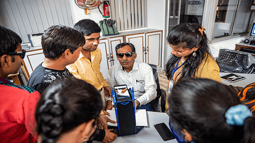 Instruktur mendemonstrasikan cara menggunakan teknologi bantuan untuk membaca braille di pusat kejuruan untuk penyandang tunanetra di India. 