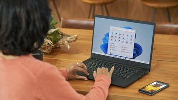 Windows 11を実行しているラップトップで作業している女性