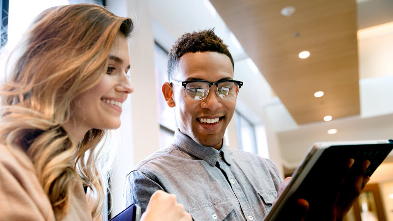 Twee informatiewerkers die naar een tablet kijken