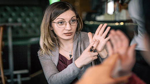 Twee vrouwen die koffie drinken in een café en gebarentaal gebruiken als communicatiemiddel.