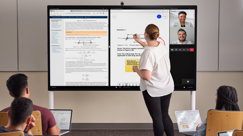 Nauczyciel stoi przed klasą i pisze na urządzeniu Hub 85" jasnoszarym piórem Surface. Aplikacje Microsoft Edge, Whiteboard i Teams są wyświetlane na ekranie. Na pierwszym planie kilku uczniów ma urządzenie Pro 7+ i sporządza notatki w programie OneNote.