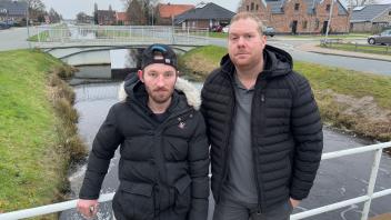 André Tammen (links) und Tim Hinrichs stehen an der Stelle, an der sie am Mittwochmorgen eine 34-jährige Autofahrerin aus dem eiskalten Wasser gerettet haben.