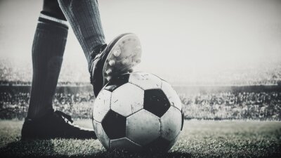 Fototapete feet of soccer player tread on soccer ball for kick-off in the stadium black and white