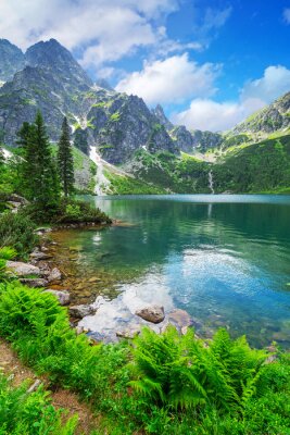 See vor dem Hintergrund der Berge und des Grüns