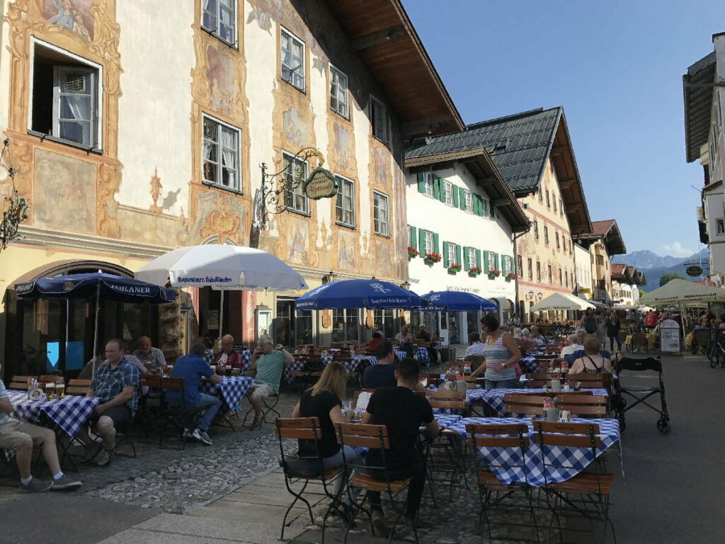 Genieße die letzten warmen Tage draußen im Herbsturlaub - am besten geht das in der Fußgängerzone in Mittenwald