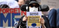 ARCHIV - 08.08.2024, Berlin: Die Teilnehmerin einer Demonstration für die Inklusion und Sichtbarkeit von Menschen mit ME/CFS hält während einer Aktion vor dem Berliner Rathaus ein Schild mit der Aufschrift "Wir fordern Aufklärung, Forschung, Versorgung". Die Zahl der Patienten, bei denen eindeutig die schwere neuroimmunologische Erkrankung ME/CFS diagnostiziert wurde, hat sich in Nordrhein-Westfalen innerhalb von zehn Jahren fast verdreifacht. (zu dpa: «Zu erschöpft für den Alltag: ME/CFS-Diagnosen verdreifacht») Foto: Soeren Stache/dpa +++ dpa-Bildfunk +++