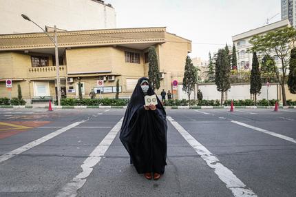 Islamische Republik: An Iranian woman lifts a Koran during a student rally in front of the embassy of Sweden in Tehran, on April 18, 2022, to protest a Swedish far-right group's plan to burn Korans. Several days of unrest in Sweden have injured several dozen people, police said, sparked by the leader of the anti-immigration and anti-Islam group Hard Line, the Danish-Swedish politician Rasmus Paludan who is aiming to drum up support ahead of September elections. (Photo by ATTA KENARE / AFP) (Photo by ATTA KENARE/AFP via Getty Images)