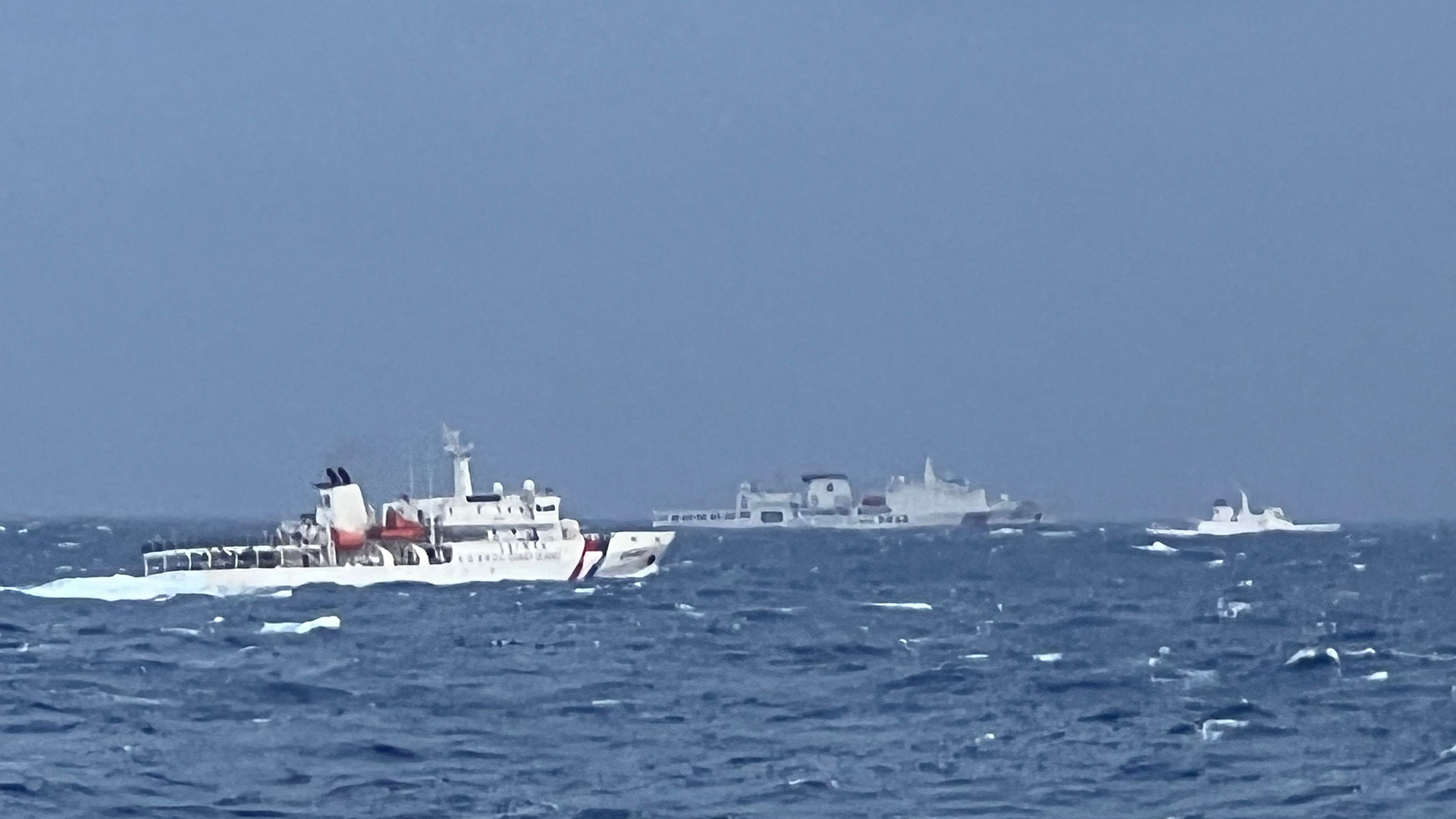 Ein chinesisches Küstenwachschiff (Mitte), das in den Gewässern östlich von Taiwan an Schiffen der taiwanesischen Küstenwache (l und r) vorbeifährt. 