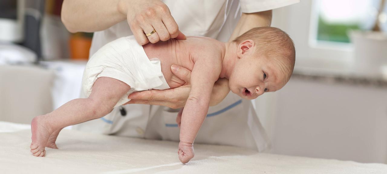 Ein Neugeborenes wird von einer Kinderärztin untersucht.