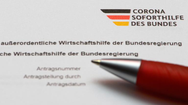 Ein Stift liegt auf einem Antragsformular zur Corona Soforthilfe des Bundes.