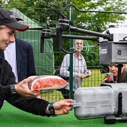 Eine Lieferdrohne wird in der Stadt Wusterhausen mit einem eingepackten Brot beladen