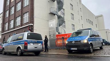 Polizeiwagen stehen vor dem Gebäude der CG Gruppe in Leipzig.